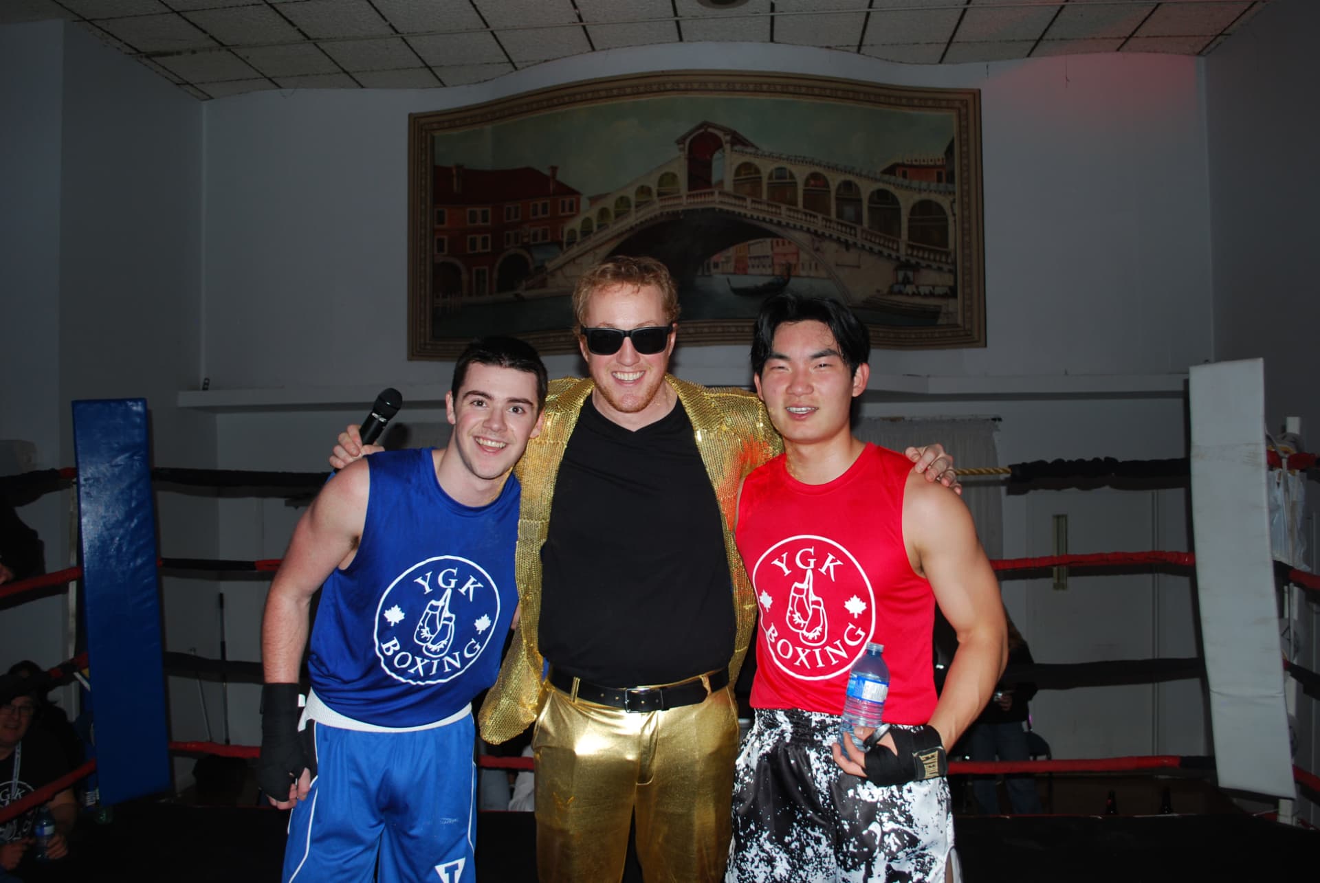 Two FFAC fighters and the ring announcer posing in the ring after a bout